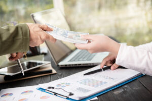 Transaction of cash between parties, symbolizing hard money lending deals.
