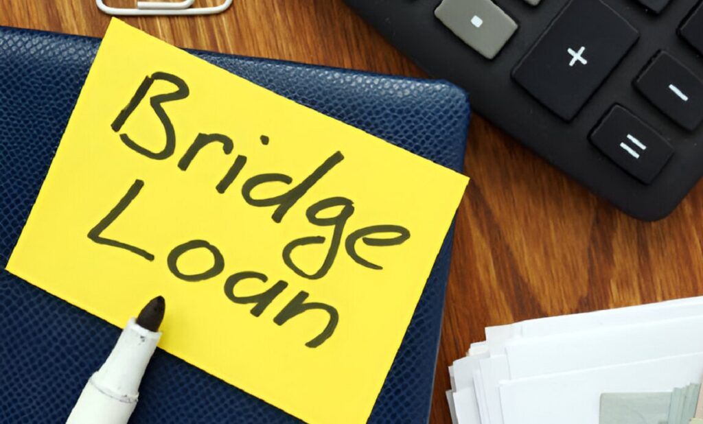Bridge loan note with calculator and money, symbolizing property finance