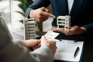 Office property loan consultation with a model building and cash exchange