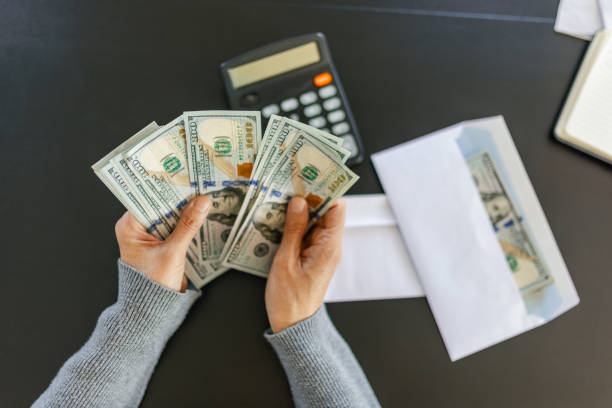 Counting money for a bridge loan transaction with calculator and envelope
