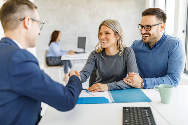 Happy clients shaking hands with an advisor after finalizing office property loan options