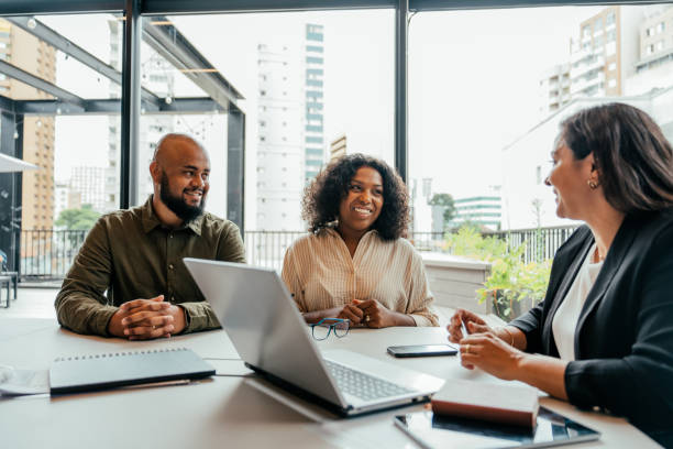 A couple consulting with an advisor about office property loan options and paperwork