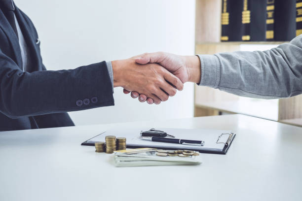A rehab hard money lender is completing a financial deal with a handshake