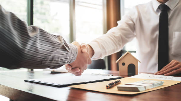 Multi family mortgage lenders and client shaking hands on property deal
