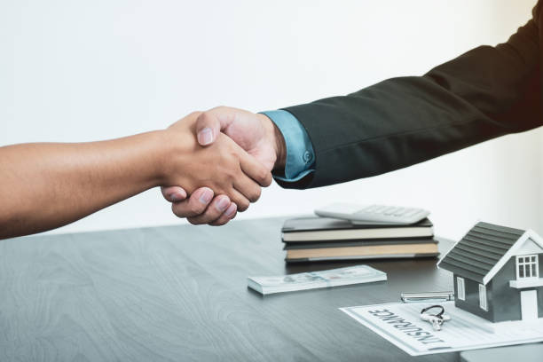 Rehab loan lender shaking hands with client after agreement finalization