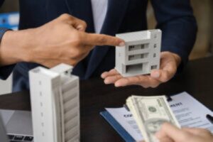 Lender showing mixed-use building model during loan discussion