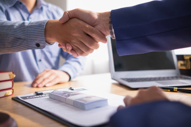 Client and the warehouse property loan lender finalize the loan contract with a handshake