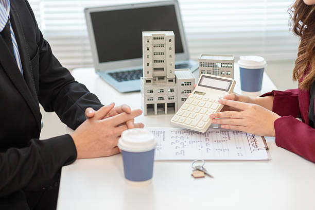 Business professionals discussing office property loans with modelsBusiness professionals discussing office property loans with models