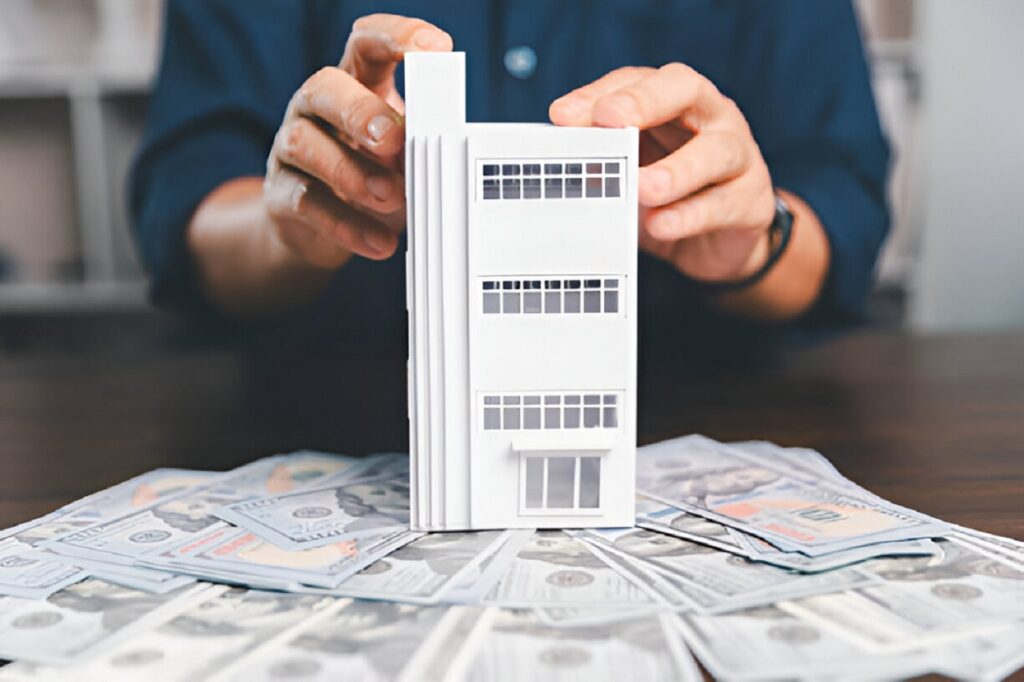 Multifamily property financing with cash and building model display