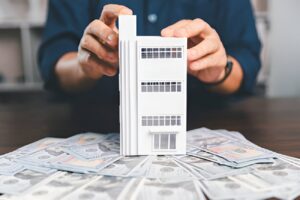 Multifamily property financing with cash and building model display