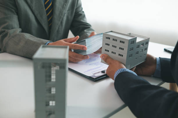 Commercial real estate loan discussion with building model and papers