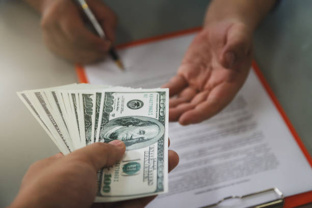 Investor handing cash for a residential hard money loan agreement