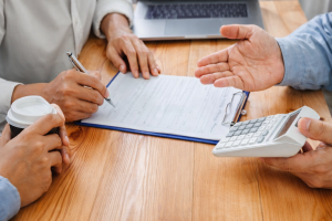 Borrower signing private loan form during funding discussion