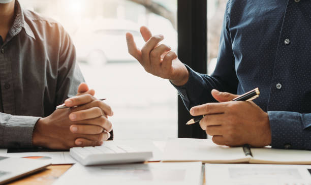 Two persons discussing bridge loan terms with documents