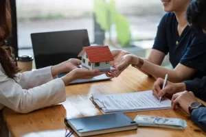 No Tax Return Loan paperwork with model house and client signing documents