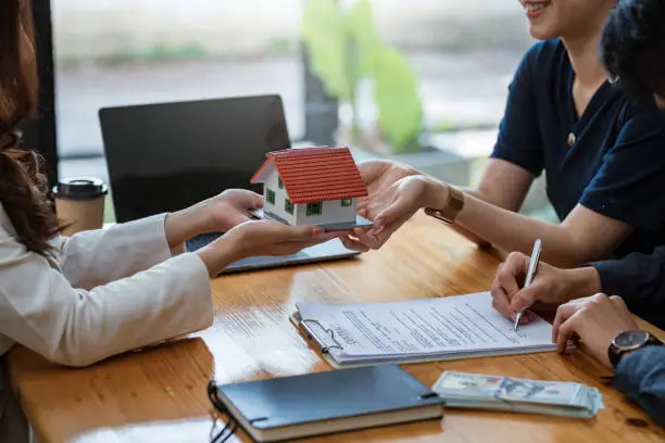 No Tax Return Loan paperwork with model house and client signing documents