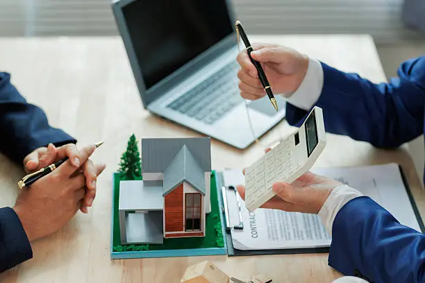 Consultant discussing no tax return loan options using architectural models