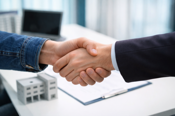 Business professionals shaking hands on warehouse loan deal